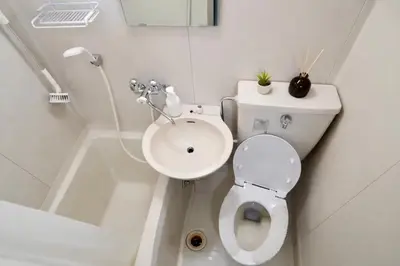 a white bathroom with a toilet and a sink at UPHouse 2C Gotokuji in Tokyo