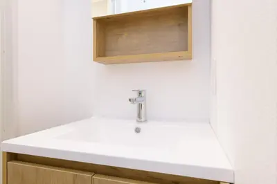a bathroom with a white sink and a wooden cabinet at 8min walk from Shibuya Sta in Tokyo