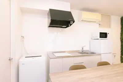 a white kitchen with a sink and a refrigerator at 8min walk from Shibuya Sta in Tokyo