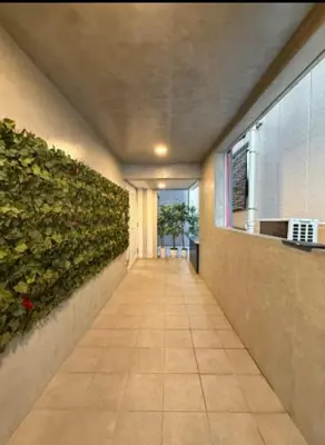 a hallway in a building with a green wall at \u4e95\u4e0a\u9054\u4e5f\u8a2d\u8a08\u73fe\u4ee3\u98a8\u65c5\u9928 \u4eac\u6210\u7dda\u99c51\u5206 \u90fd\u5fc3\u79fb\u52d5\u4fbf\u5229 \u8fd1\u5317\u5343\u4f4f\u4e0a\u91ce\u6d45\u8349\u9280\u5ea7\u30b9\u30ab\u30a4\u30c4\u30ea\u30fc Wifi\u9577\u671f\u53ef WAGAMAMA\u5343\u4f4fS03\u5ba4 Y01\u5ba4 Y03\u5ba4 in Tokyo