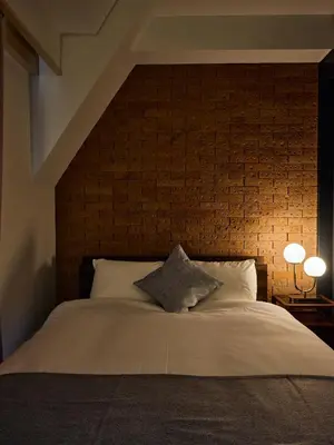 a bedroom with a large bed with a brick wall at 5min to Shibakoen 49square meters Cozy Stay Near Tokyo Tower in Tokyo