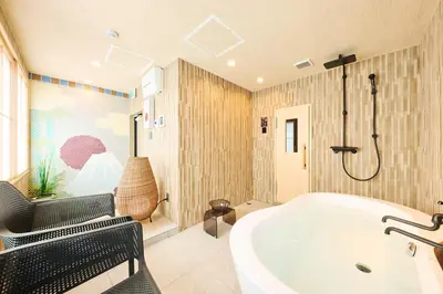 a bathroom with a tub and a chair and a shower at \u30de\u30a4\u30b0\u30ec petit \u6e0b\u8c37\u539f\u5bbf in Tokyo