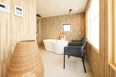 a bathroom with a tub and a chair and a sink at \u30de\u30a4\u30b0\u30ec petit \u6e0b\u8c37\u539f\u5bbf in Tokyo