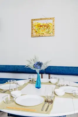 a table with plates and a blue vase with flowers at \u5e61\u30f6\u8c37\u306e\u30cf\u30bf\u30b4\u30e4 in Tokyo