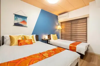 a bedroom with two beds and a blue wall at My Sumida Home 2A in Tokyo