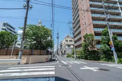 an empty city street with a tower in the distance at My Sumida Home 2A in Tokyo