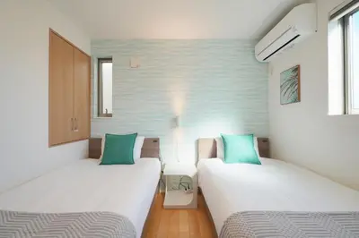 two beds in a small room with green pillows at Renovation Open! Tokyo Sumida Tachibana Residence, 5minutes on foot from the station in Tokyo
