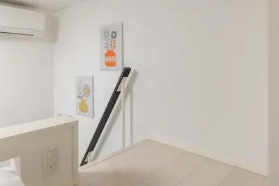 a staircase in a white room with art on the wall at ParkSide \u5927\u4e45\u4fdd\u99c5\u5f92\u6b6910\u5206 \u97d3\u56fd\u30b0\u30eb\u30e1\u3092\u697d\u3057\u3080 \u65b0\u5bbf \u6e0b\u8c37 \u539f\u5bbf\u3078\u597d\u30a2\u30af\u30bb\u30b9 \u6700\u59272\u540d in Tokyo