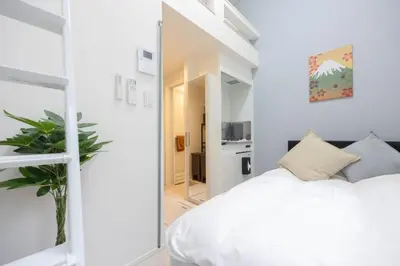 a bedroom with a white bed and a mirror at ParkSide \u5927\u4e45\u4fdd\u99c5\u5f92\u6b6910\u5206 \u97d3\u56fd\u30b0\u30eb\u30e1\u3092\u697d\u3057\u3080 \u65b0\u5bbf \u6e0b\u8c37 \u539f\u5bbf\u3078\u597d\u30a2\u30af\u30bb\u30b9 \u6700\u59272\u540d in Tokyo