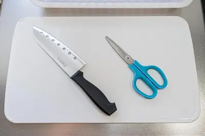 a pair of scissors sitting on a white cutting board at Mori House \u5fd7\u83022-3F in Tokyo