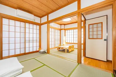 a room with a bed and a door and windows at Mori House \u5fd7\u83022-3F in Tokyo
