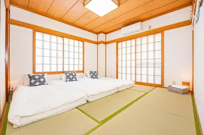 a bedroom with a large bed in a room with windows at Mori House \u5fd7\u83022-3F in Tokyo