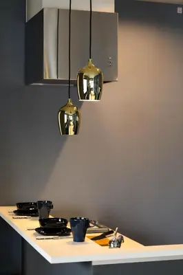 a kitchen counter with three lights above a stove at the Moto Hotel Ueno in Tokyo