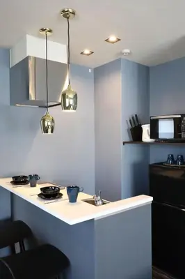 a kitchen with a white counter and blue walls at the Moto Hotel Ueno in Tokyo