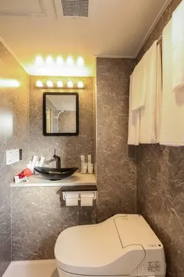 a bathroom with a toilet and a sink at the Moto Hotel Ueno in Tokyo