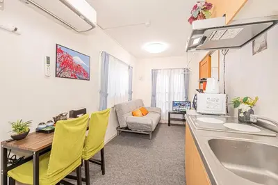 a kitchen with a sink and a table with yellow chairs at Akihabara Skytree Premium Apartment 401 in Tokyo