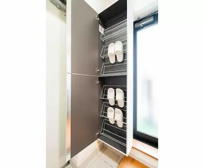 a walk in closet with black shelves and white shoes at Akihabara Skytree Premium Apartment 401 in Tokyo