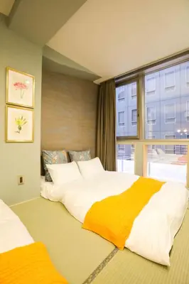 a bedroom with a large bed and a window at the Moto Hotel Shinjuku in Tokyo