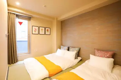 a bedroom with two beds and a window at the Moto Hotel Shinjuku in Tokyo