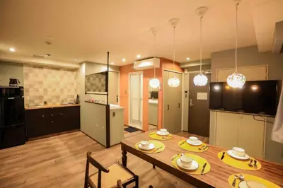 a kitchen and a dining room with a table and chairs at the Moto Hotel Shinjuku in Tokyo