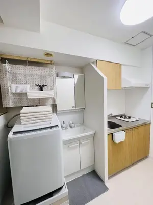 a small kitchen with a white refrigerator and a sink at HAMAMATSUCHO Mansion #Minato-Ku in Tokyo
