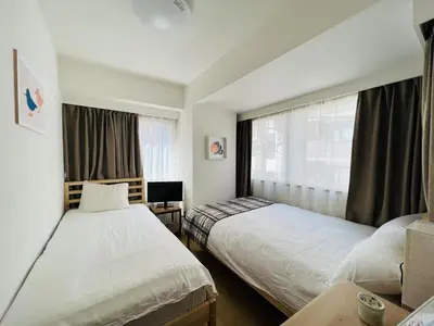 a hotel room with two beds and a window at HAMAMATSUCHO Mansion #Minato-Ku in Tokyo