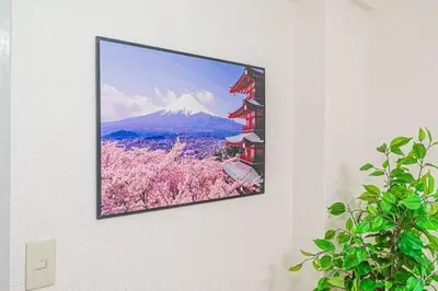 a flat screen tv hanging on a wall with a mountain at My Sumida Home 2B in Tokyo