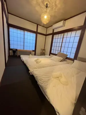 two beds in a room with three windows at \u5fb9\u6c5f\u6238\u5ddd in Tokyo