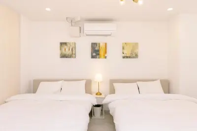 two beds in a room with white walls at 8min walk from Shibuya Sta Universal design in Tokyo