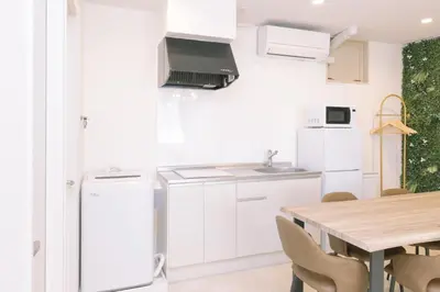 a kitchen with white cabinets and a wooden table at 8min walk from Shibuya Sta Universal design in Tokyo