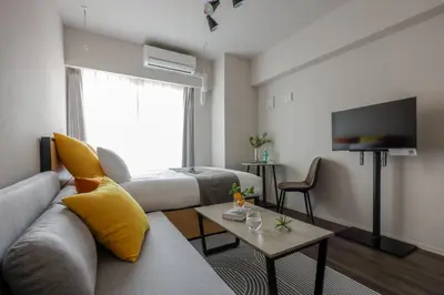 a living room with a couch and a tv at The Parkcross\u83ca\u5ddd in Tokyo