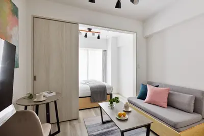 a living room with a couch and a bed at The Parkcross\u83ca\u5ddd in Tokyo