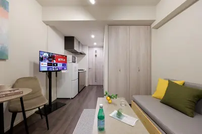 a living room with a couch and a table and a television at The Parkcross\u83ca\u5ddd in Tokyo