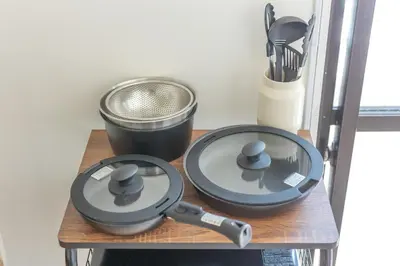 a table with two pans and a strainer at Kinshicho First Rooftop in Tokyo