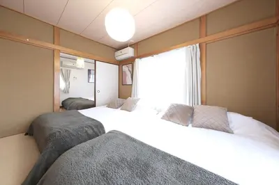 a bedroom with two white beds and a window at Poco Land in Tokyo
