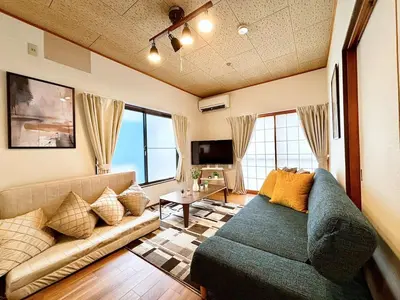 a living room with a couch and a tv at Poco Land in Tokyo