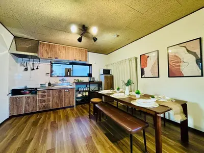 a kitchen with a wooden table and a dining room at Poco Land in Tokyo