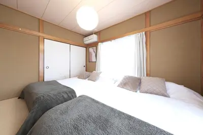 a bedroom with two beds and a window at Poco Land in Tokyo