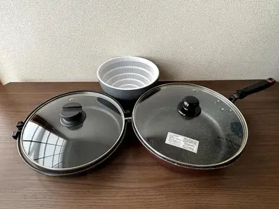 two pans sitting on top of a wooden table at Poco Land in Tokyo