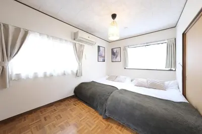 a bedroom with a large bed in front of a window at Poco Land in Tokyo