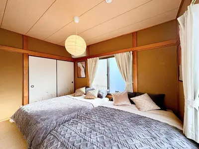 a large bed in a room with windows at Poco Land in Tokyo