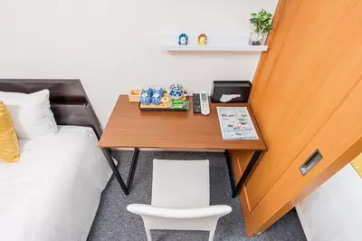 a room with a desk with a bed and a phone at Akihabara Skytree Premium Apartment 102 in Tokyo