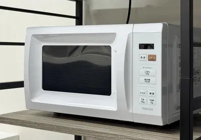 a white microwave oven sitting on top of a table at Conveniently located 10 min walk from Shin-Okubo Station and 7 min walk from Higashi-Shinjuku Station -Okubo hosuse- in Tokyo