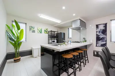 a kitchen with a large island with stools at Conveniently located 10 min walk from Shin-Okubo Station and 7 min walk from Higashi-Shinjuku Station -Okubo hosuse- in Tokyo