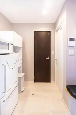 a kitchen with a black door and a refrigerator at \u5922\u306e\u5bbf\u5f69\u308a 127t in Tokyo