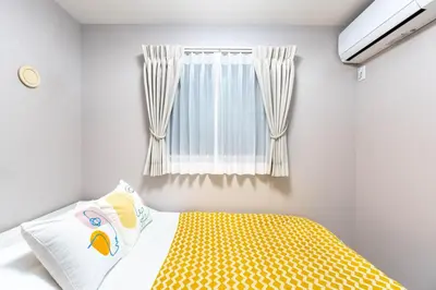 a bedroom with a yellow bed and a window at \u5922\u306e\u5bbf\u5f69\u308a 127t in Tokyo