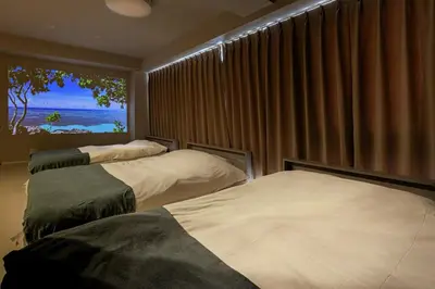 a bedroom with two beds and a window with the ocean at 365Ueno in Tokyo