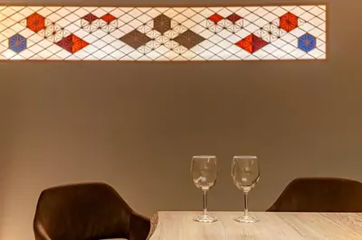 two wine glasses sitting on a table in front of a stained glass window at 365Ueno in Tokyo