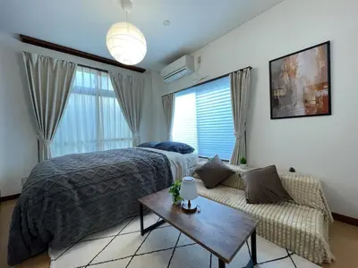 a bedroom with a bed and a couch and a table at Poco Inn in Tokyo