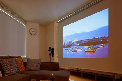 a large projection screen in a living room with a couch at HeySky Oshiage in Tokyo